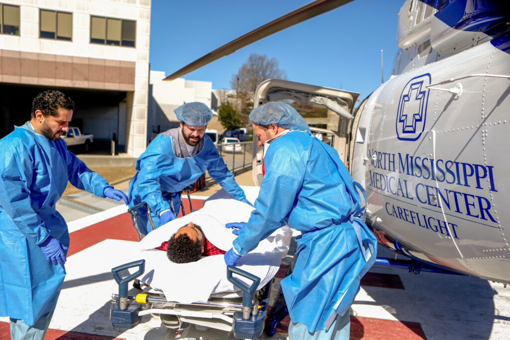 Relias doctors helping a patient off the flight for life helicopter.